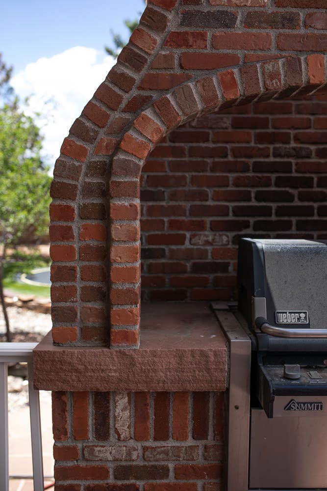 half image of a brick oven with a grill